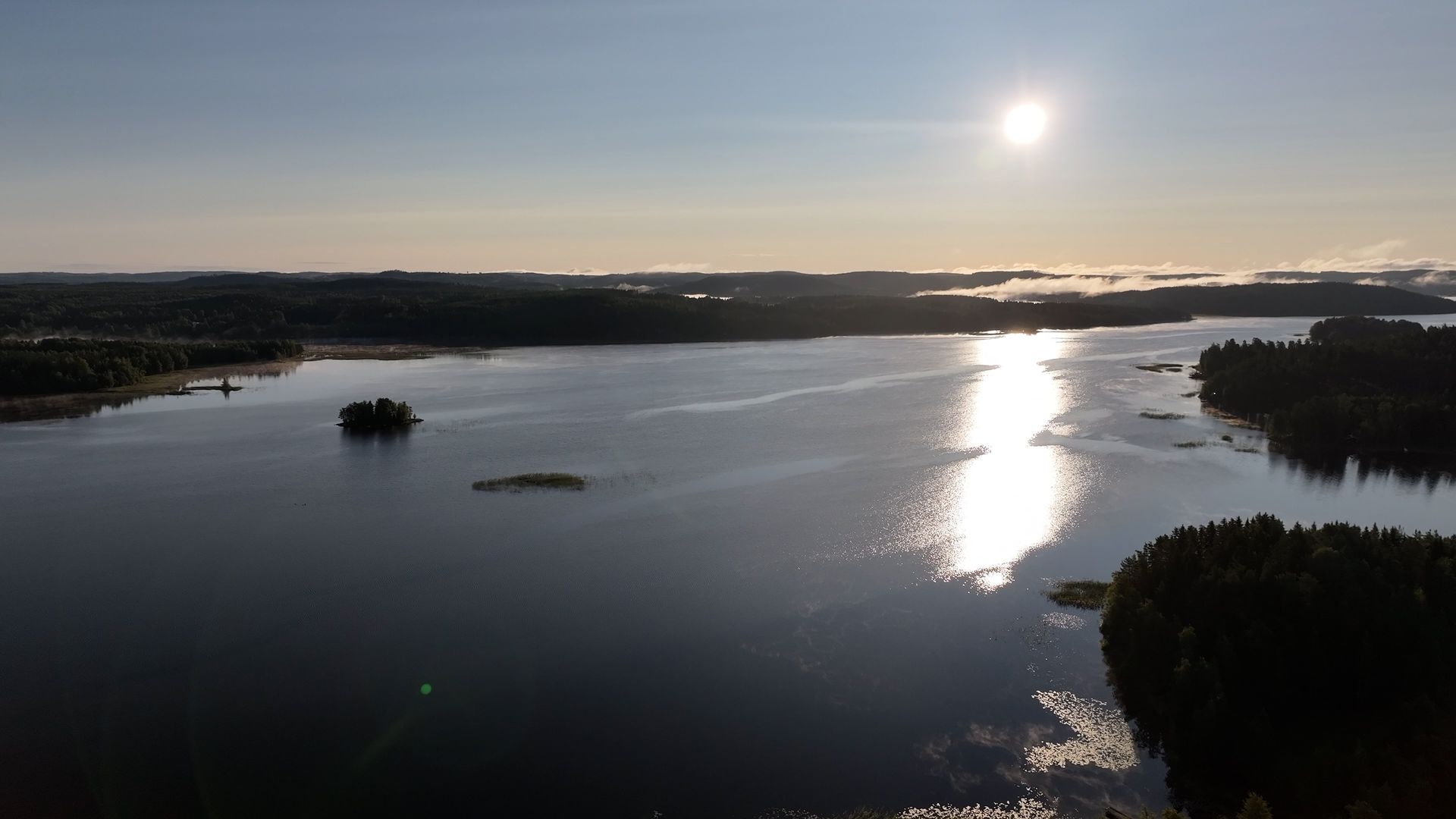 Aerial view of a lake and forested islands in evening light