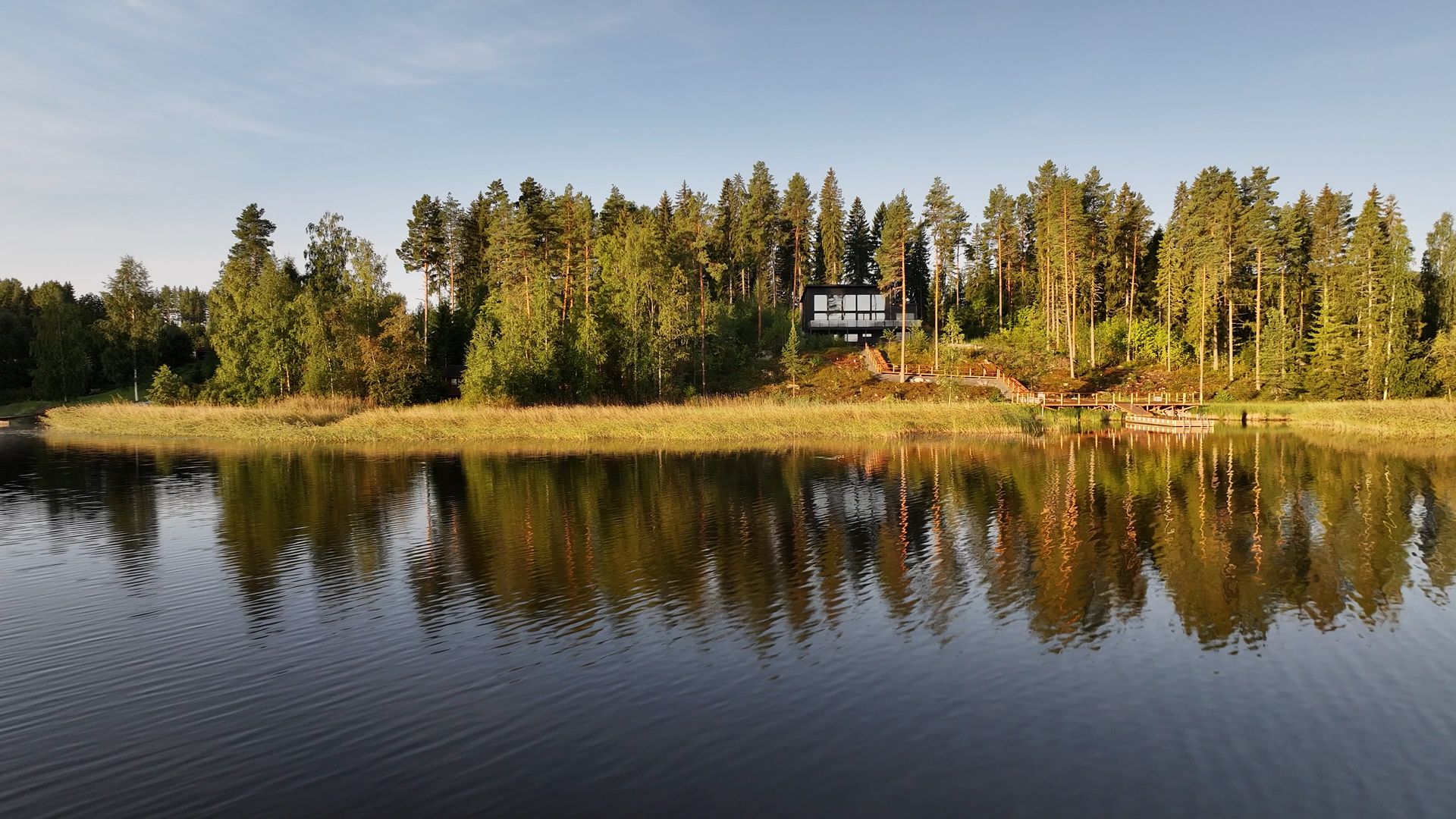 The lakeside villa in Himos reflected in calm water