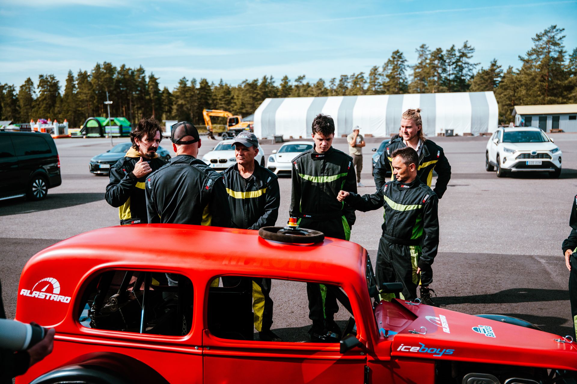Track briefing beside a red Legend car at Alastaro